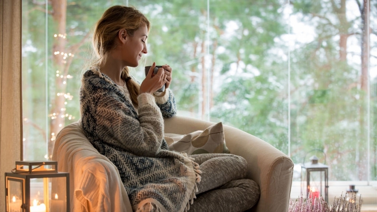 Young woman sitting at home by the window