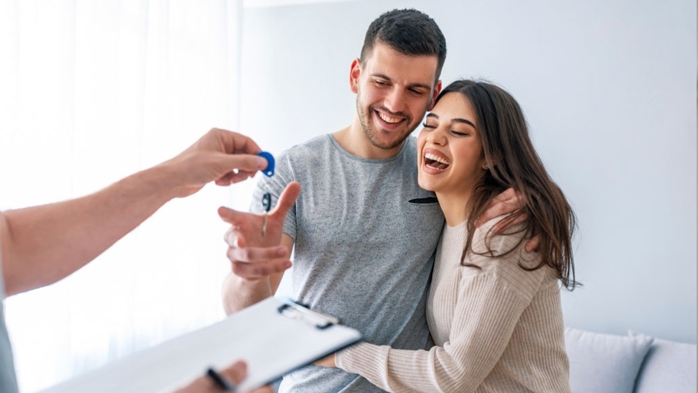 Happy couple is taking keys of new house