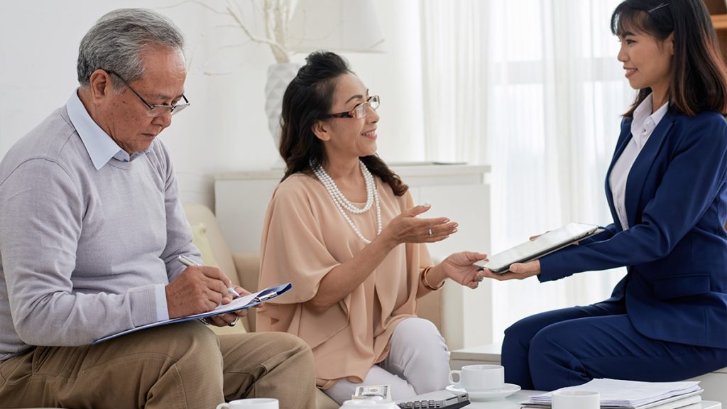 Senior couple signing real estate documents