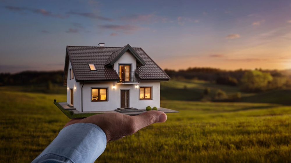 Male hand showing offering a new dream house at the empty field