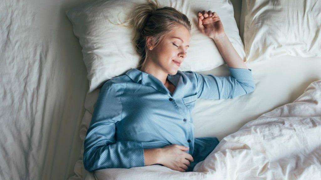 Pretty blonde woman in blue pajamas sleeping