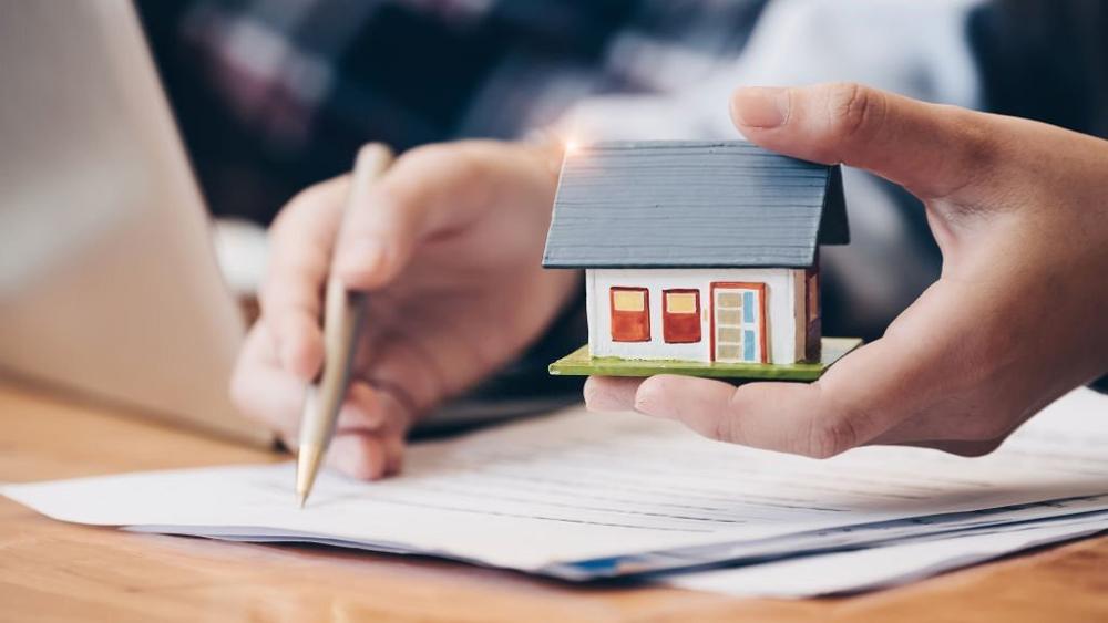 Real estate agent with house model signing contract