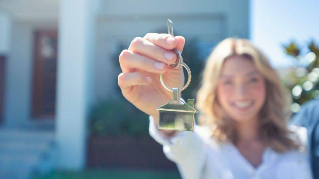 Young woman holding the key to her new house