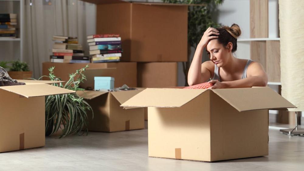 Sad tenant getting ready to move to new home and boxing belongings