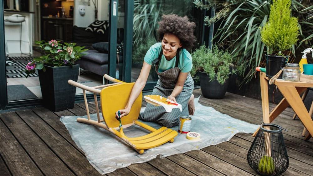 Woman is coloring a chair at home