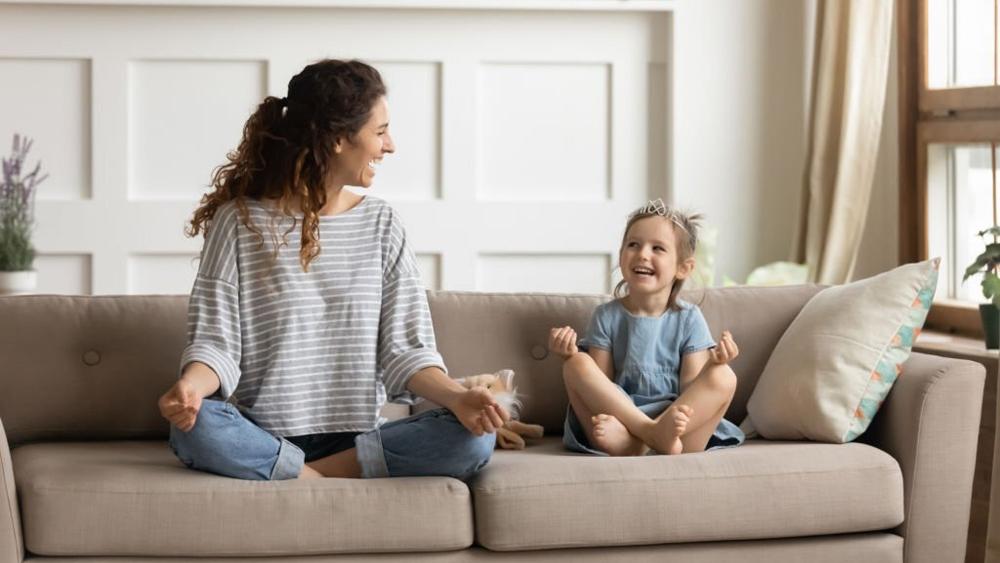 Happy mommy practicing yoga with small child