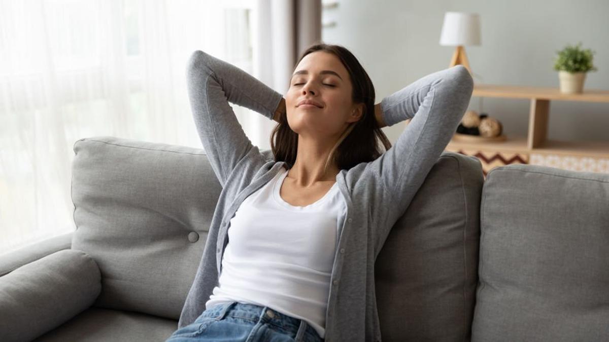 Relaxed young woman lounge on-comfortable sofa at home