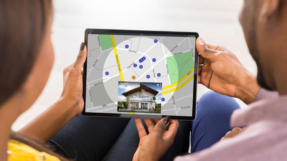 Young couple using tablet to sell house