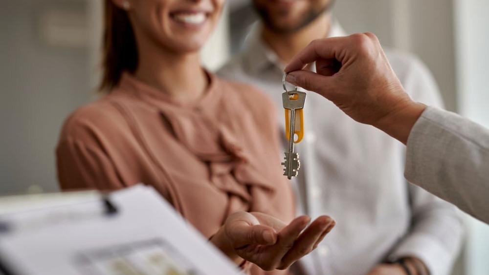 Couple receiving new house keys from real estate agent