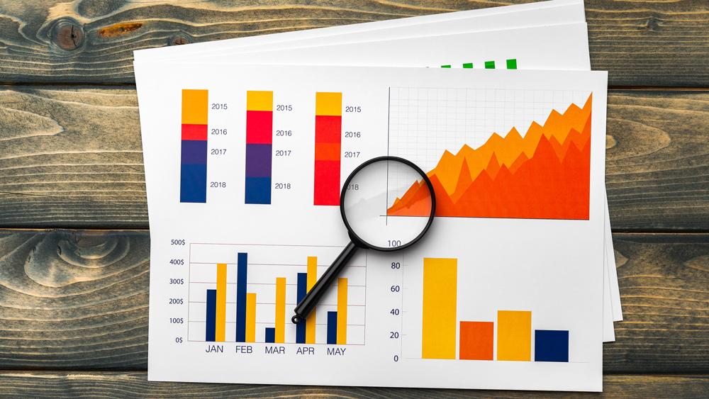 Estate purchase graphs and magnifying glass on table