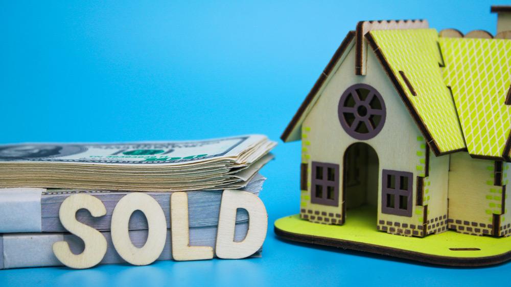 House model and money with the word sold