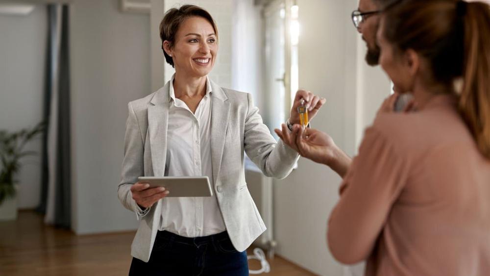 Real estate agent giving a couple keys of new home for rent