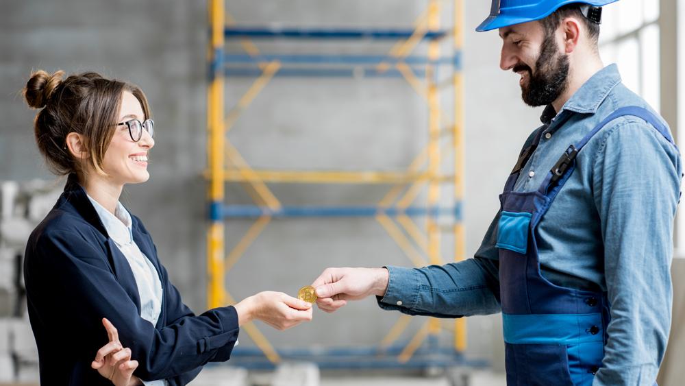 Woman giving cryptocurrency to a builder