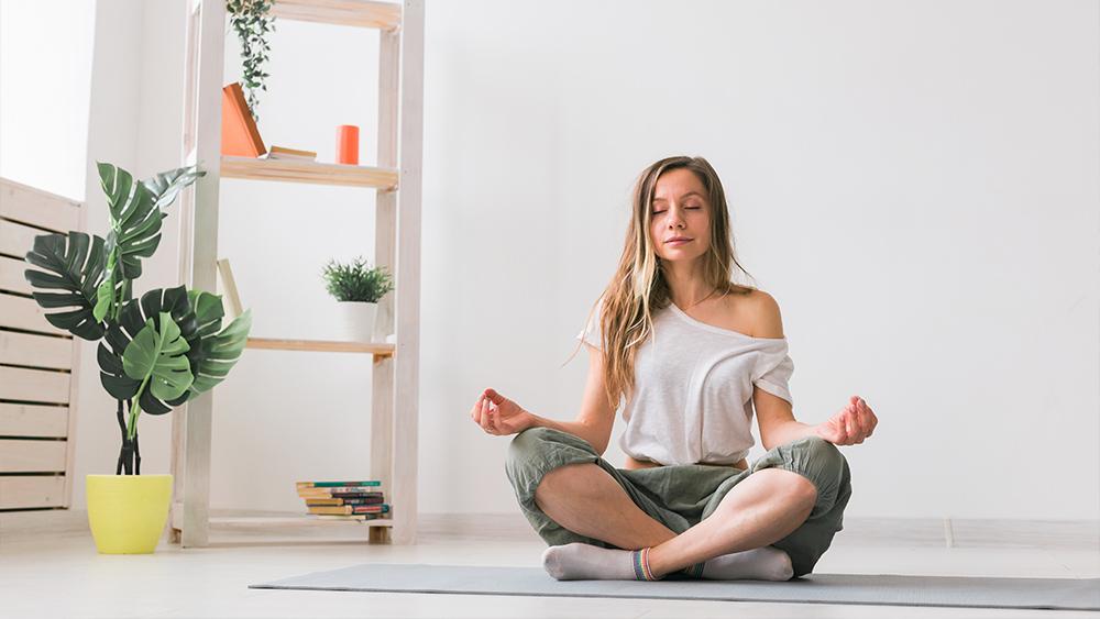 Young woman in the lotus position while meditating