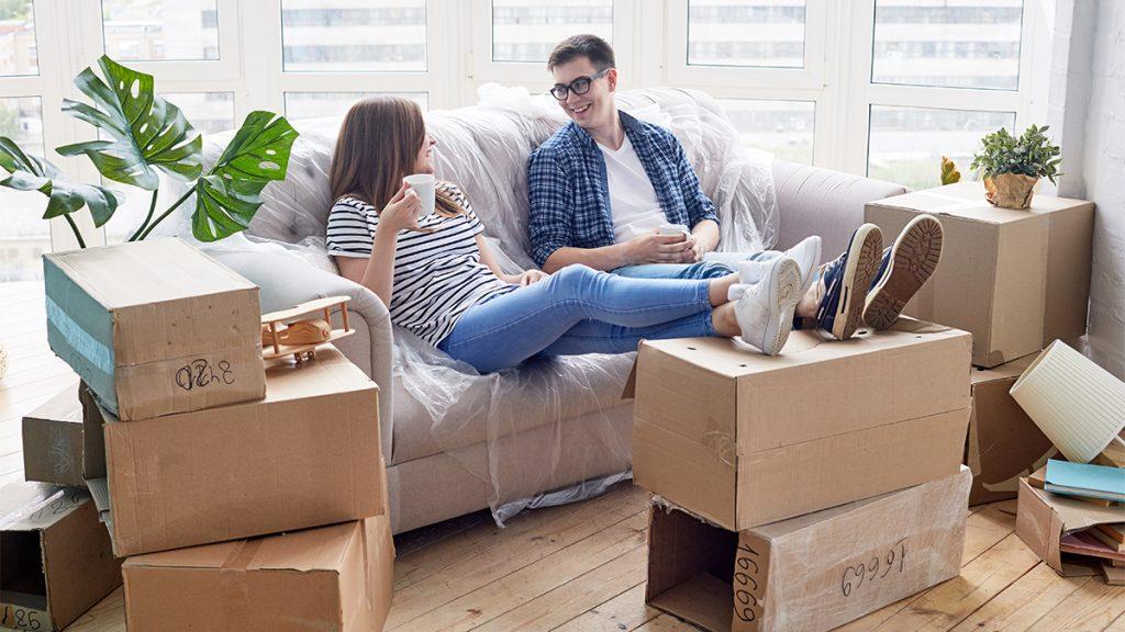 Couple taking rest after relocating to new apartment