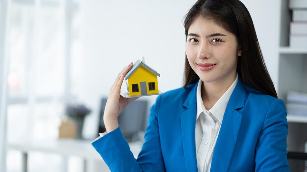 Real estate house agent showing house model