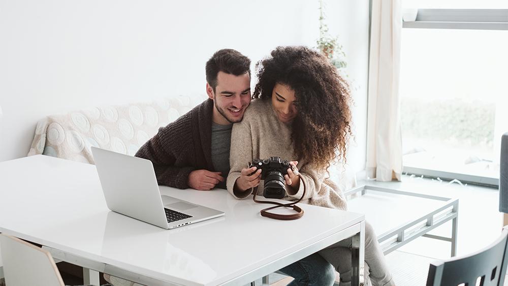 Couple looking at photos in camera at home