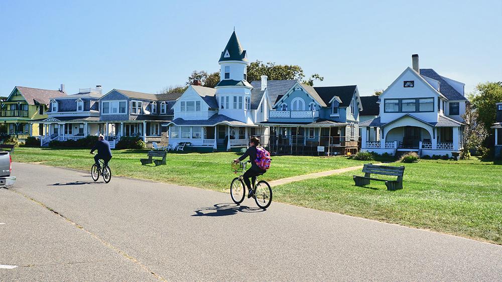 People riding their bikes in a neighborhood
