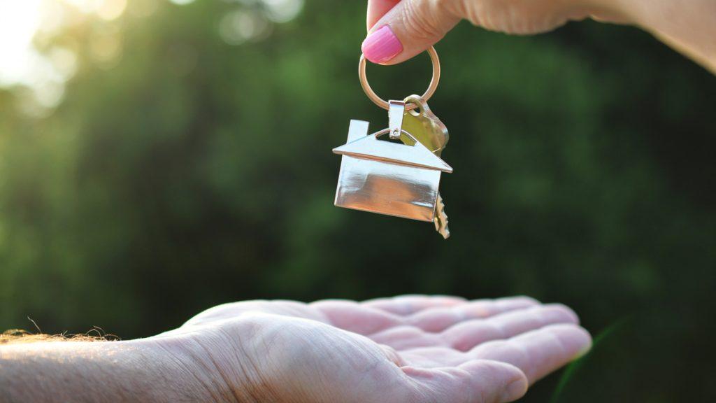 Realtor handing a man the key to his new home