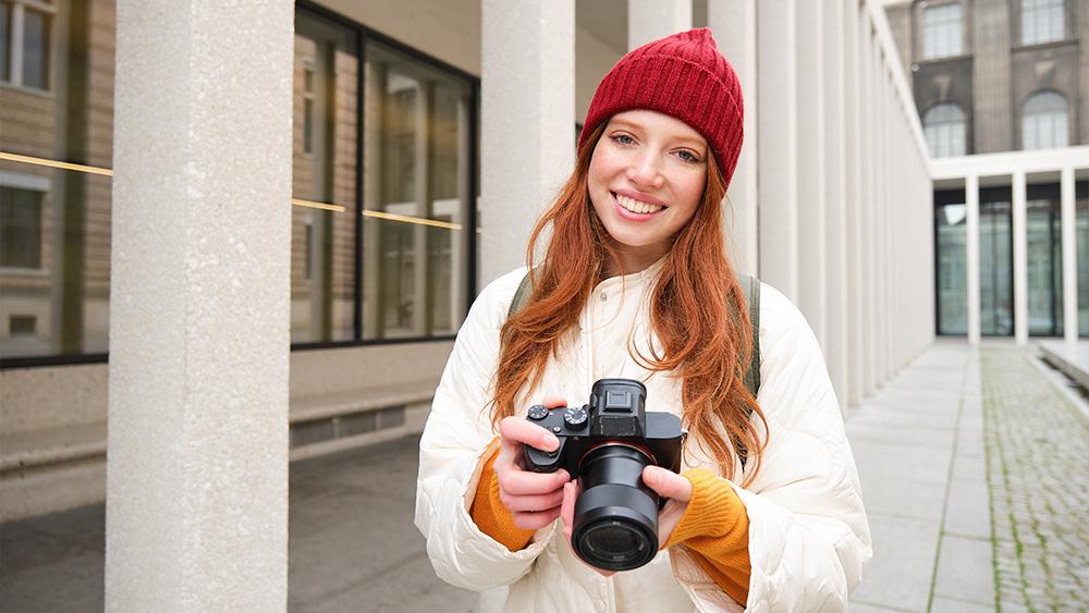 Smiling girl photographer taking pictures from home for sale