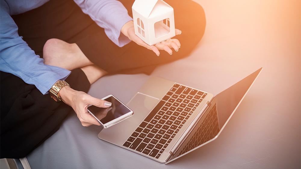 Woman's hand keeping house model in front of laptop