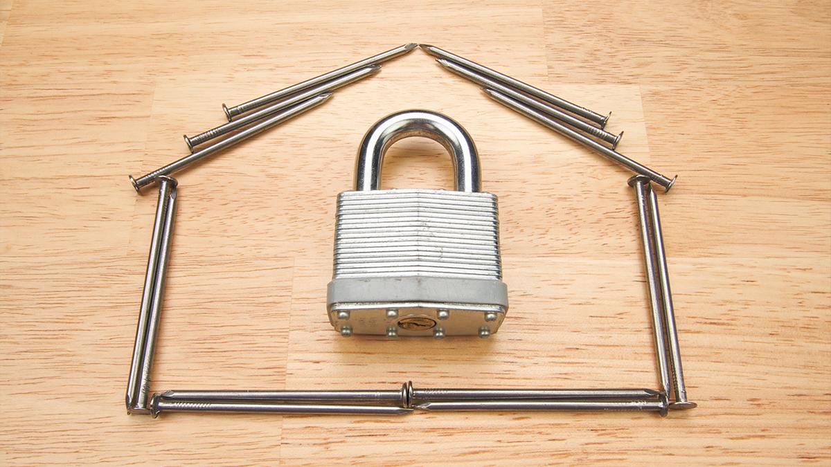 Home security concept shown by a lock and some spikes