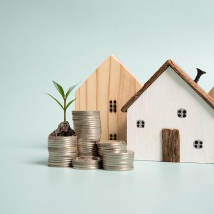 Wooden house models with saving money to buy or rent a house concept Wooden house models with saving money to buy or rent a house concept